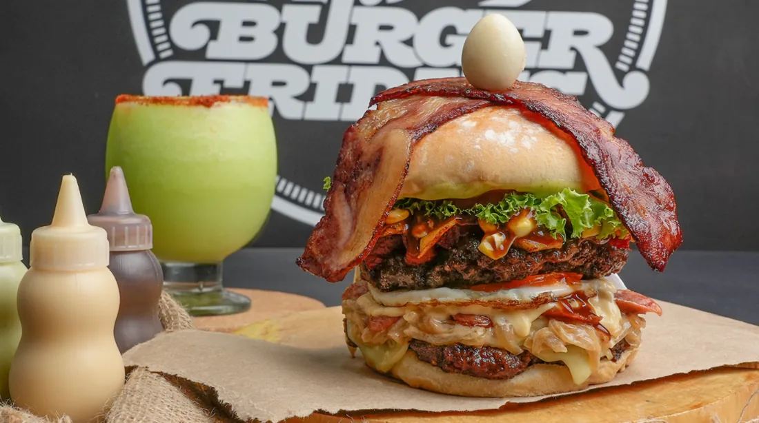 Fotografía gastronómica: hamburguesa artesanal con bebida verde en restaurante