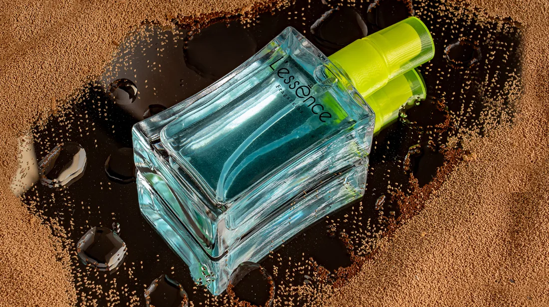 Fotografía de producto: frasco de perfume azul sobre fondo de tonos café